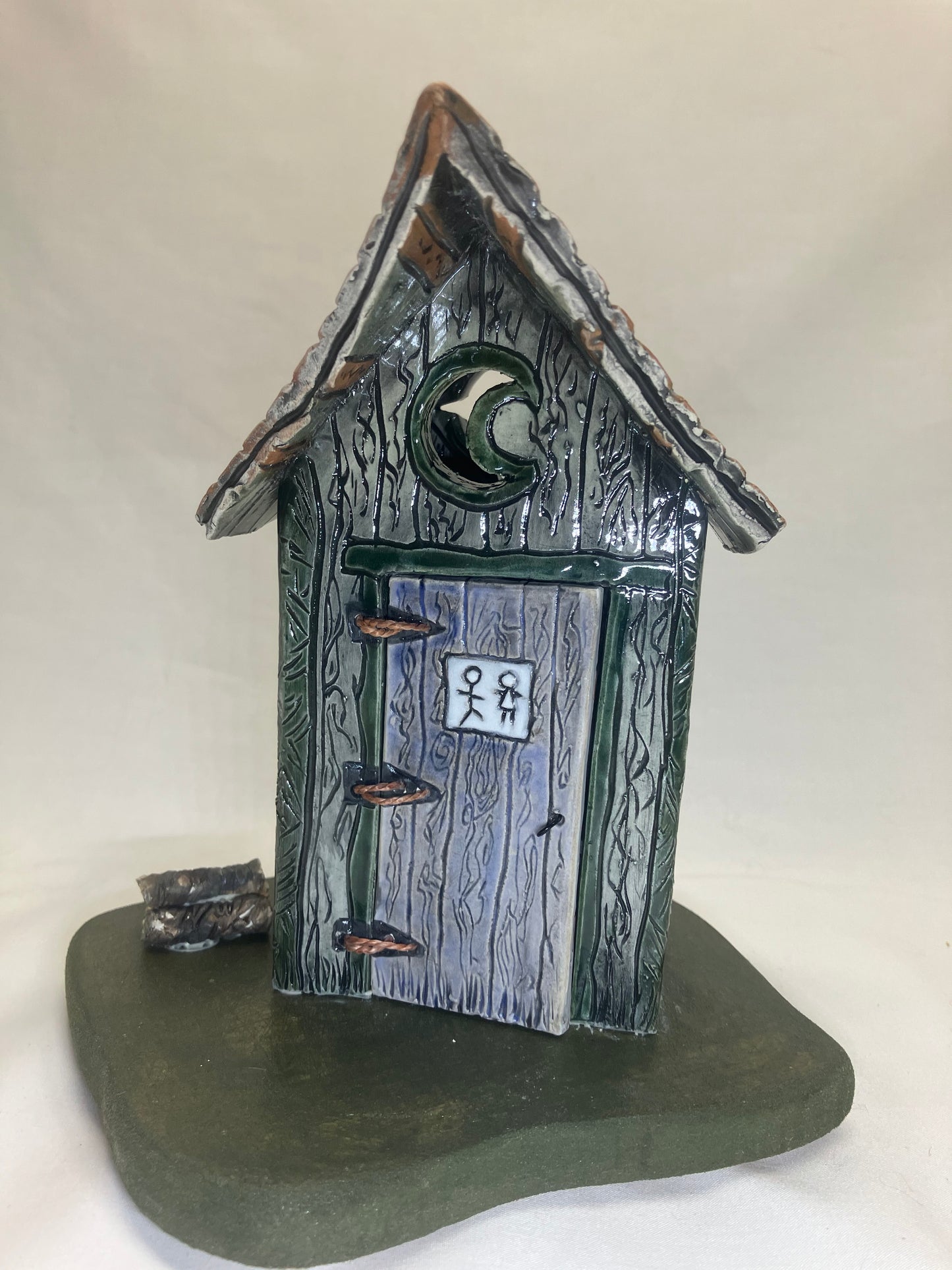 Grey and green outhouse