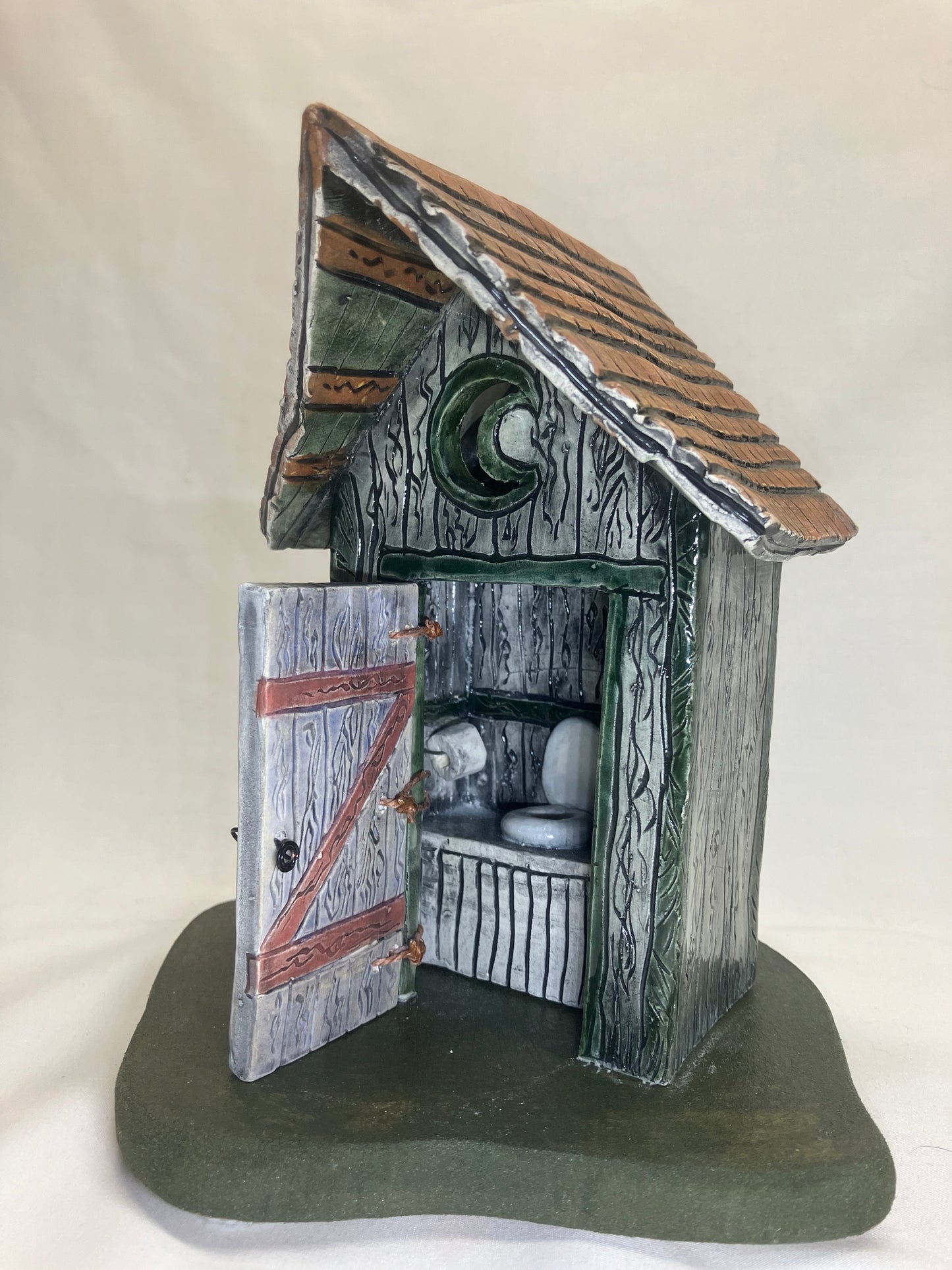 Grey and green outhouse