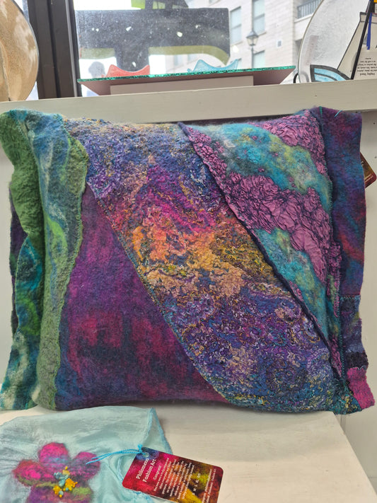 Purple multicoloured decorative pillow by Denise Uebele with layered blue, teal, green, and golden accents