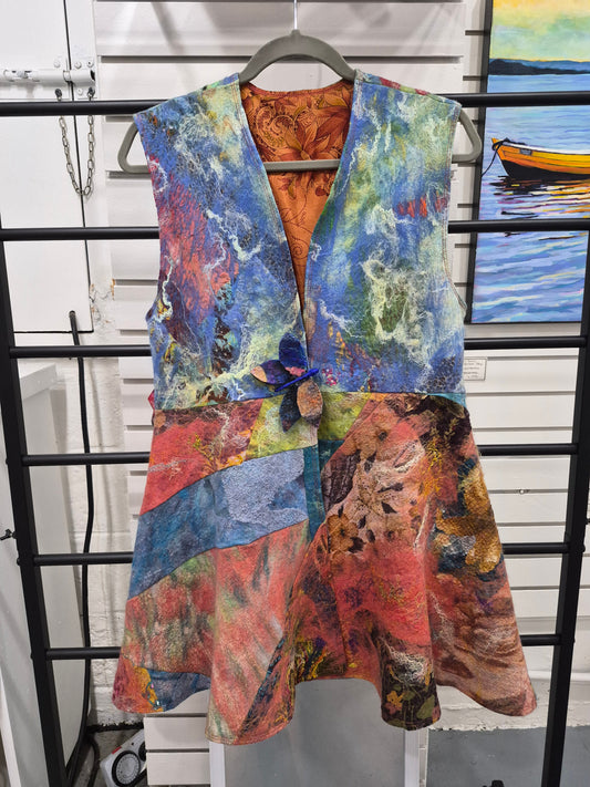 Denise Uebele’s autumn vest with blue, green, rust, and gold patchwork and botanical patterns